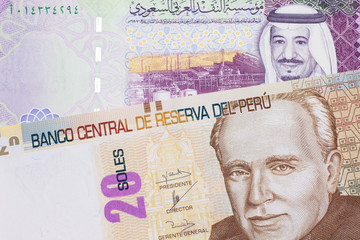 Fototapeta na wymiar A pastel colored, twenty Peruvian sol bank note, close up in macro with a colorful Saudi five riyal bank note