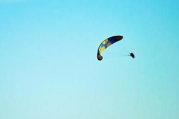 Extreme paragliding in the blue sky. High up flying. Sport and activity.