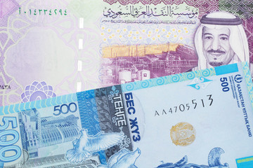 A five riyal note from Saudi Arabia paired with a blue, five hundred tenge bank note from Kazakhstan