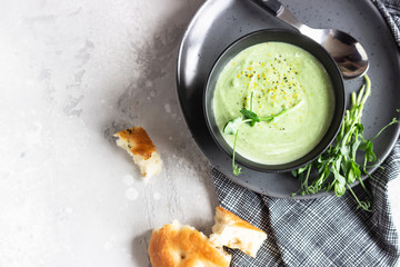 Vegan cream soup with avocado and spinach served with micro greens and bread. Diet food concept. Vegetarian and vegan food. Top view. 