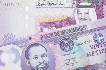 A purple, twenty metical note from Mozambique close up with a red, one hundred Saudi Arabian riyal note