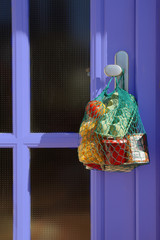 delivery during the quarantine. Shopping bag with Merchandise, goods and food is hanging at the...