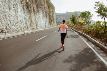 Fitness sport girl resting after intensive run, young attractive runner taking break after jogging outdoors