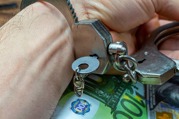 removing handcuffs from hands on a money banknotes background.