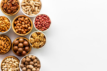 Set of macadamia, hazelnut, walnut, almond, pistachio, pecans nuts on white background top-down frame copy space