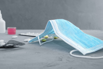 medications that ease the symptoms of a viral disease and a medical mask are on the table