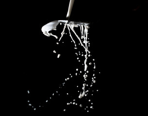Fototapeta na wymiar splashes and jets of milk on a black background