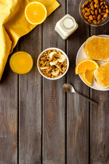 Vegetarian breakfast with granola and fruits on wooden background top-down frame copy space