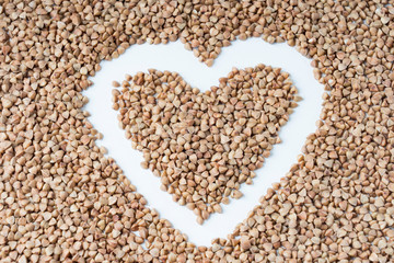 buckwheat heart shape close-up on a white background, selective focus, tinted image
