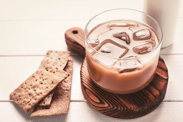 Glass of tasty iced coffee on table