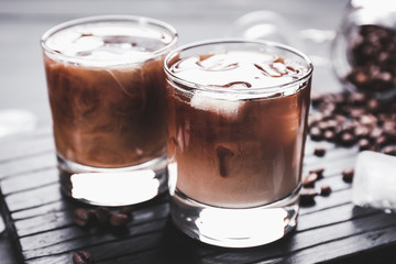 Glasses of tasty iced coffee on table
