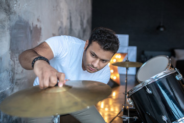 Dark-haired young man in a white tshirt looking involved
