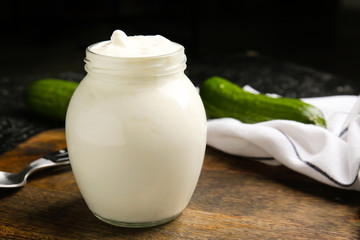 Jar with tasty sour cream on table