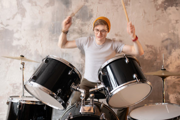 Young man in a red hat playing the drums