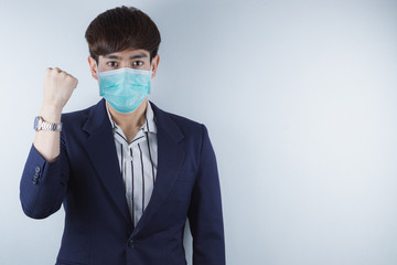 The business man wearing mask for protecting coronavirus and pm 2.5 and show his hand to fight them. Coronavirus and Air pollution pm 2.5 concept.