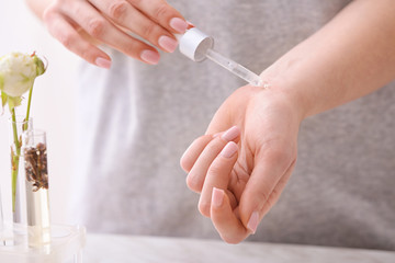 Woman applying perfume oil onto skin, closeup
