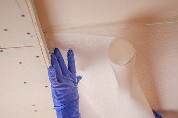 The Builder puts plaster on the wall.Hand holding a spatula with construction mix and smoothes out...