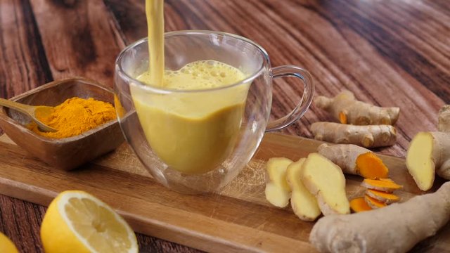 Immunity Boosting Antivirus Drink. Healthy Turmeric Latte Drink With Almond Milk In A Glass Cup. 