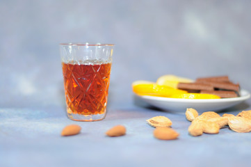 Crystal glass of cognac plate with slices of lemon and pieces of chocolate and a scattering of...