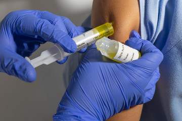 Nurse injecting the coronavirus vaccine.  The syringe has the 2019-NcOv vaccine.