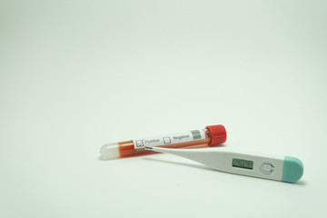 Blood test of the coronavirus with a thermometer.  The blood tube is positive.  The thermometer reads 40 degrees, a symptom of the 2019-nCov.