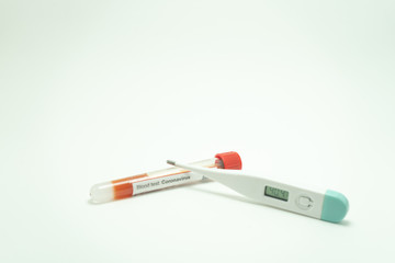 Obraz premium Blood test of the coronavirus with a thermometer. The blood tube is positive. The thermometer reads 40 degrees, a symptom of the 2019-nCov.