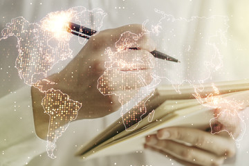 Abstract creative digital world map and man hand writing in diary on background, globalization concept. Multiexposure