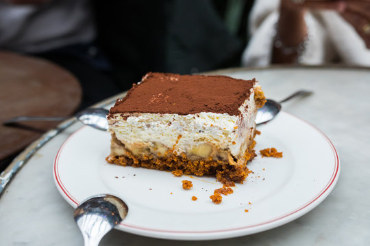 Banofeemisu close up, La Felicita, Paris, France. Beautiful close of a revisited Tiramisu on a white plate. Ingredients : Speculos, banana, mascarpone, cocoa powder. Delicious thick italian dessert.