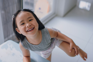 Asian girl with black hair aged 2-4 years old. Beautiful smile, fun playing and laughing brightly. Open your mouth wide to see the teeth.