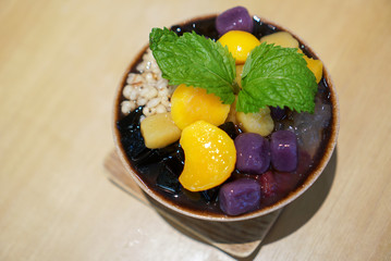 Taiwanese shaved ice with toppings, mango, grass jelly, red beans, aloe vera jelly, taro ball and tofu pudding. Top view.