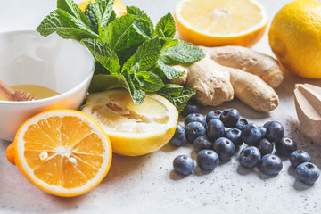 Healthy ingredients for immunity and anti-flu. Citrus fruits, ginger, honey, blueberries and mint on a white background, health concept.