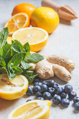 Healthy ingredients for immunity and anti-flu. Citrus fruits, ginger, honey, blueberries and mint on a white background, health concept.