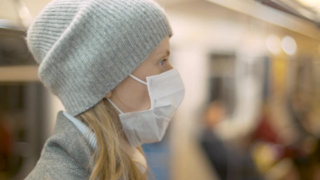 Close Up Profile Portrait Of Young Woman In Protective Mask In The Subway Car. Blurry Unrecognizable Passengers. Healthy And Safety Lifestyle Concept. Covid-19 Pandemic