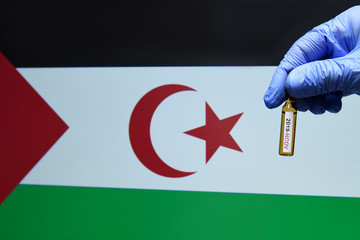Corona virus or Covid-19 in sahrawi Arab democratic republic flag , sample blood tube in hand with...