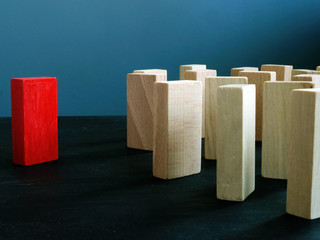 Stand out from the crowd. Unique as leader red block opposite wooden.