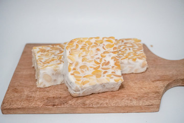 three pieces of organic food tempeh on a wooden tray