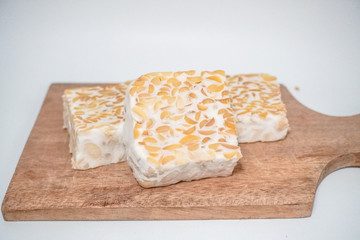 three pieces of organic food tempeh on a wooden tray