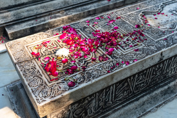 ornamented old marble Muslim grave with flowers