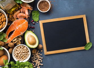 Empty chalkboard for your text with Food sources of omega 3 and healthy fats. Foods high in fatty acids including vegetables, seafood, nut and seeds