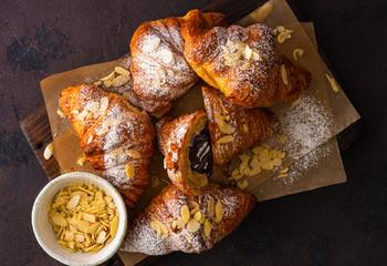 Breakfast croissant with chocolate on a dark stone background top view