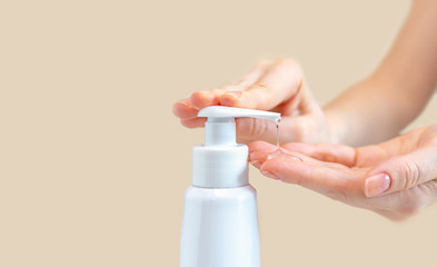 A female press on a bottle with antibacterial gel to clean and wash hands of bacteria and virus...