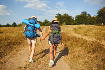 Hiking couple with backpack walking on hike in nature