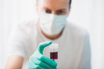 Doctor holds blood tube test, concept of coronavirus pandemic.