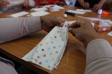 Young women helping to sew nose masks to prevent covic disease 2019