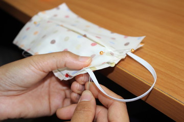 Young women helping to sew nose masks to prevent covic disease 2019