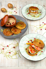 Set of three plates with potato pancakes. Traditional food of russian cuisine. Lunch menu of food restaurant on white wooden background in rustic style, side view
