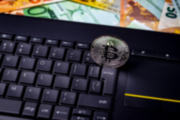 Euro bills, black keyword and metal souvenir bitcoin. The concept of electronic money, online...