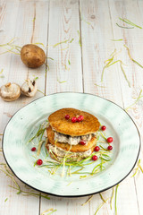 Draniki with mushrooms and cranberries in sour cream sauce on white wooden background in rustic style, example of menu in traditional belorussian restaurant