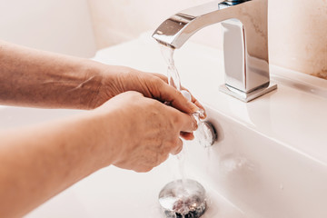 Sanitary treatment - woman lathers her hands in the bathroom