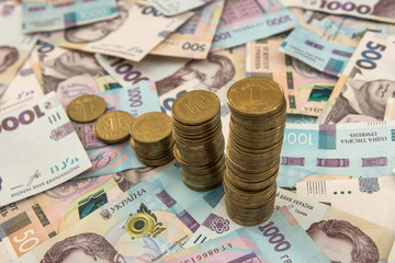 diagram of coin  money growth effect with lot of ukraine money banknotes. For business growth and financial concept